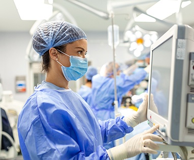 Medical team member looking at computer in surgical setting